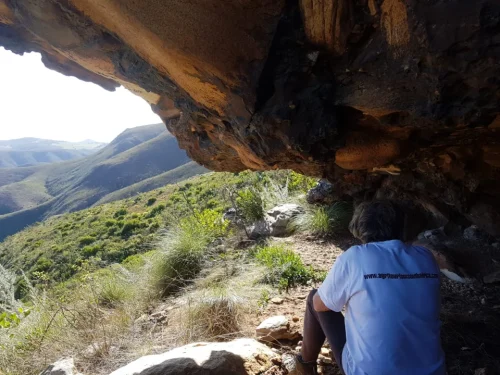 Maggie sitting under over-hanging rock formation